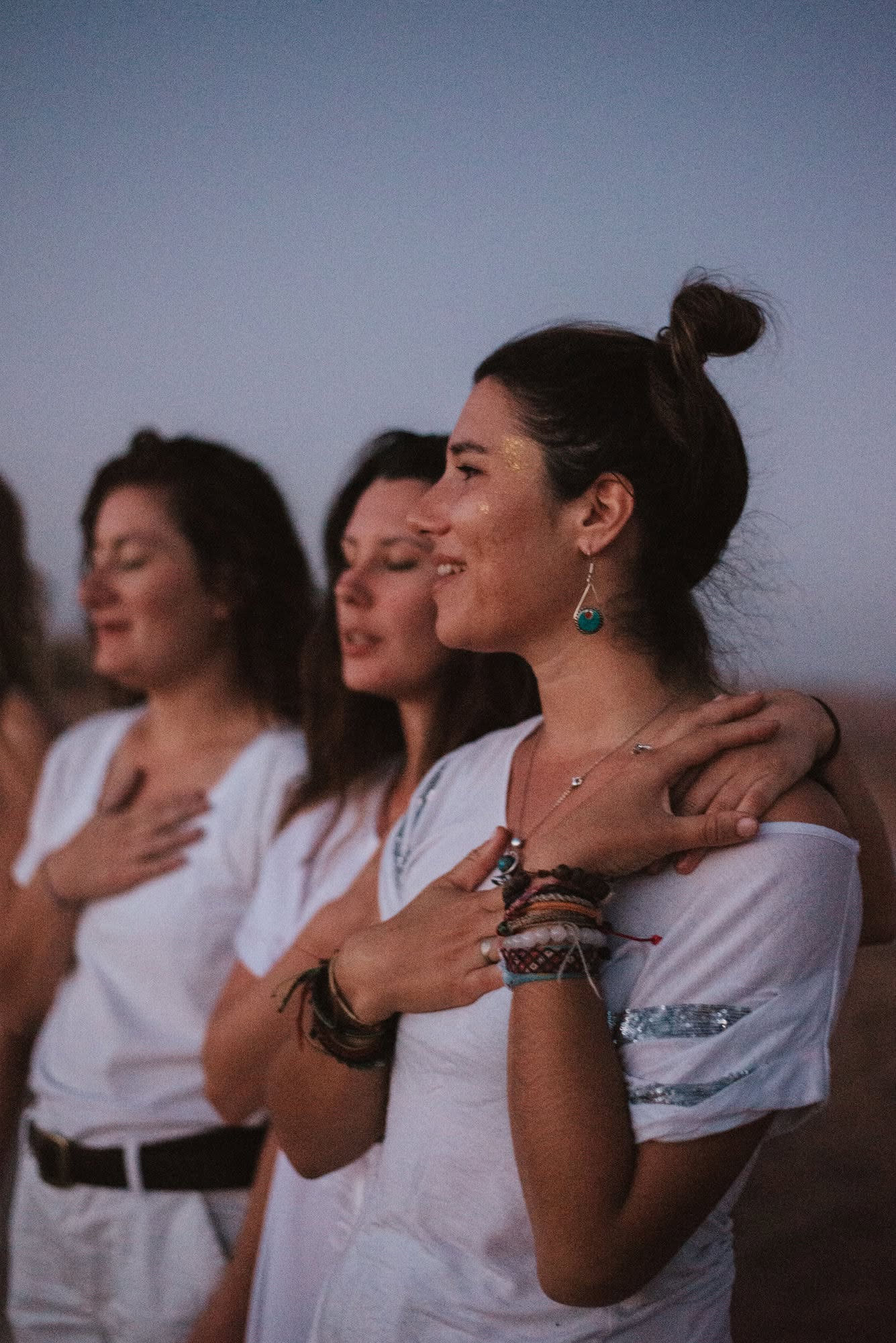 Une photo de Mélodie et d'autres femmes assises en position de méditation, se tenant toute la main pour illustrer les cercles de femmes.